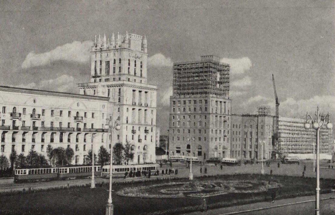 Trams and buses on Station Square in Minsk in 1951–1952, one new tower finished and its twin still in scaffolding beside a crane
