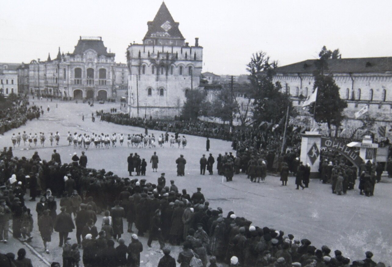Spectators lining Sovetskaya Square in Gorky in 1943 as runners pass the kremlin's Dmitrievskaya Tower towards the finish
