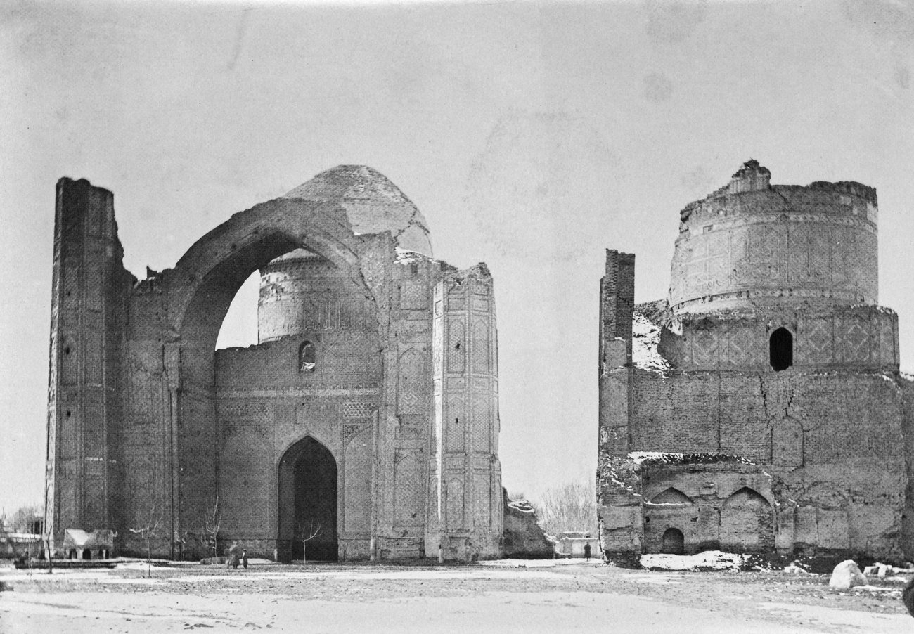 The ruined portal arch and dome of the Bibi-Khanym Mosque and its smaller northern mosque above a snowy square in Samarkand in 1883