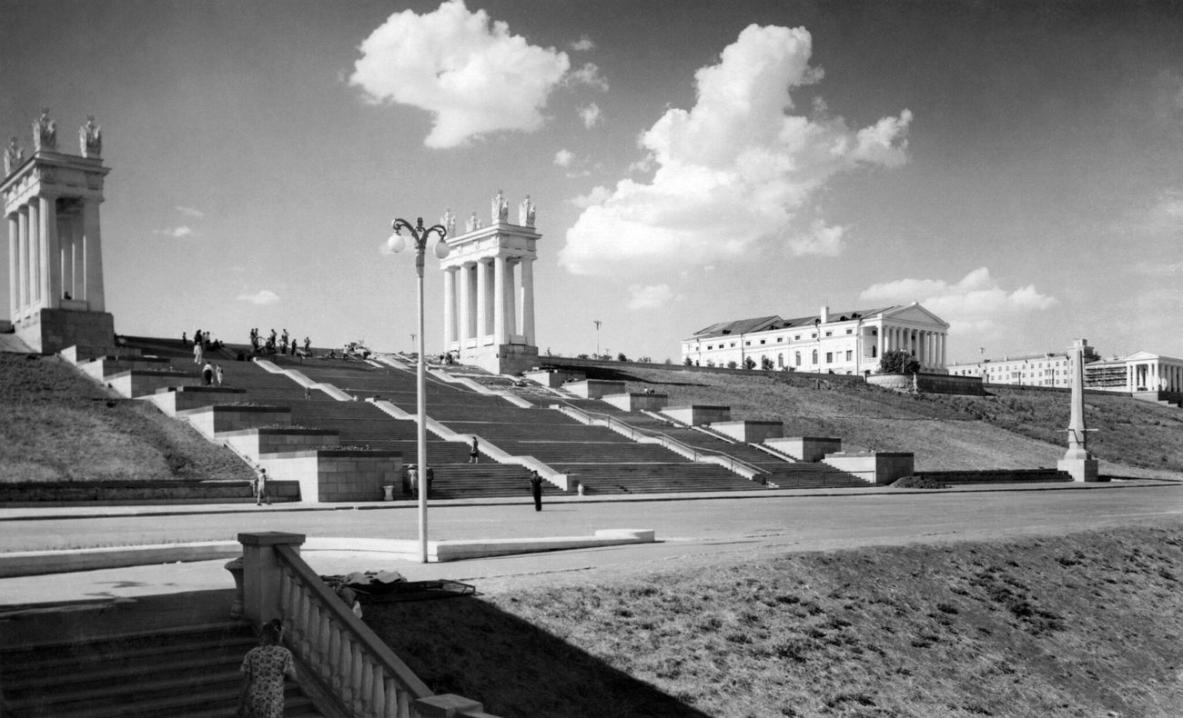 The colonnaded propylaea and broad staircase of the rebuilt Volga embankment in Stalingrad, today Volgograd, in 1952, under summer clouds