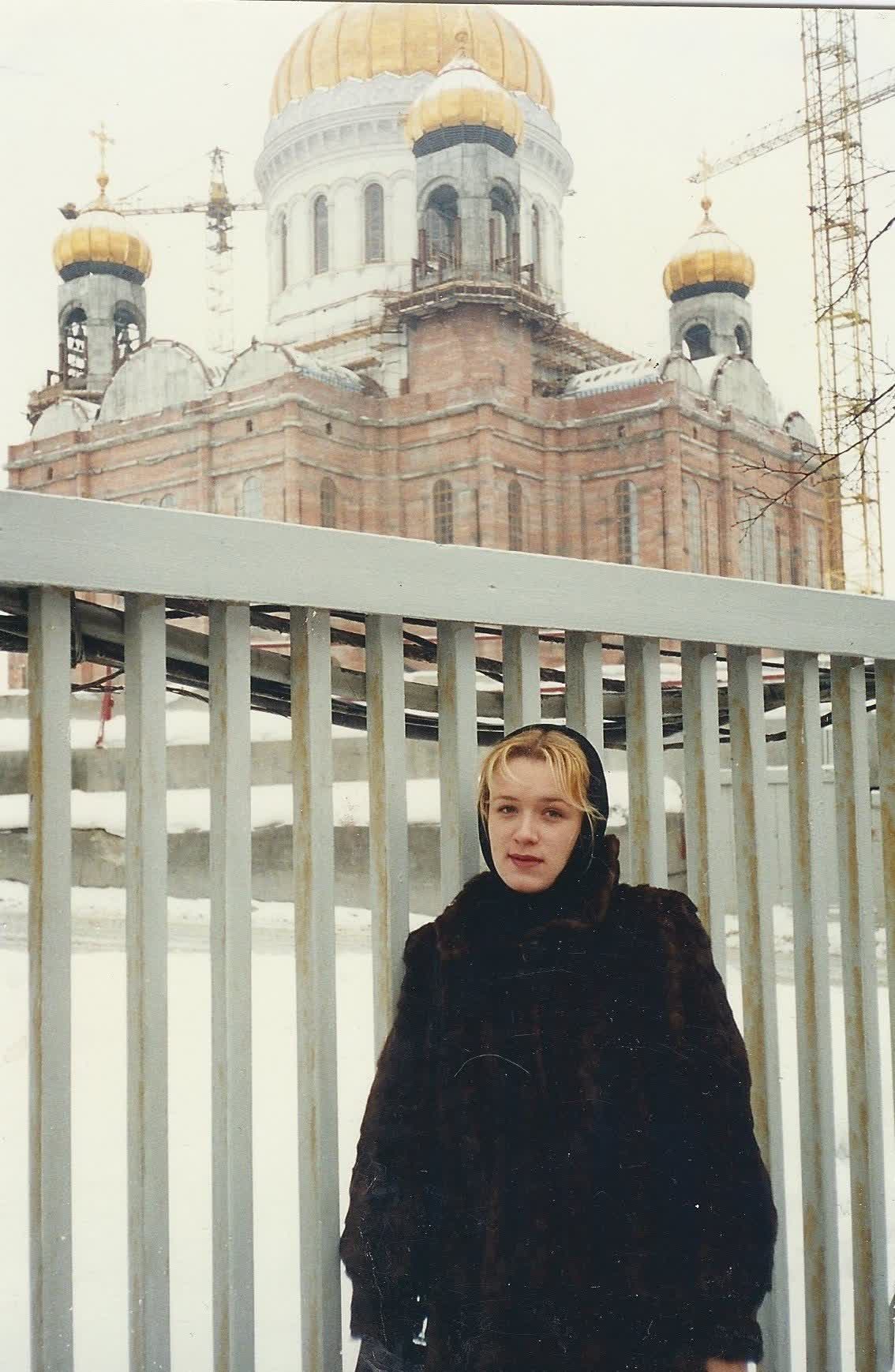 The rebuilt Cathedral of Christ the Saviour in Moscow in 1996, its gold domes restored, with a woman in the foreground