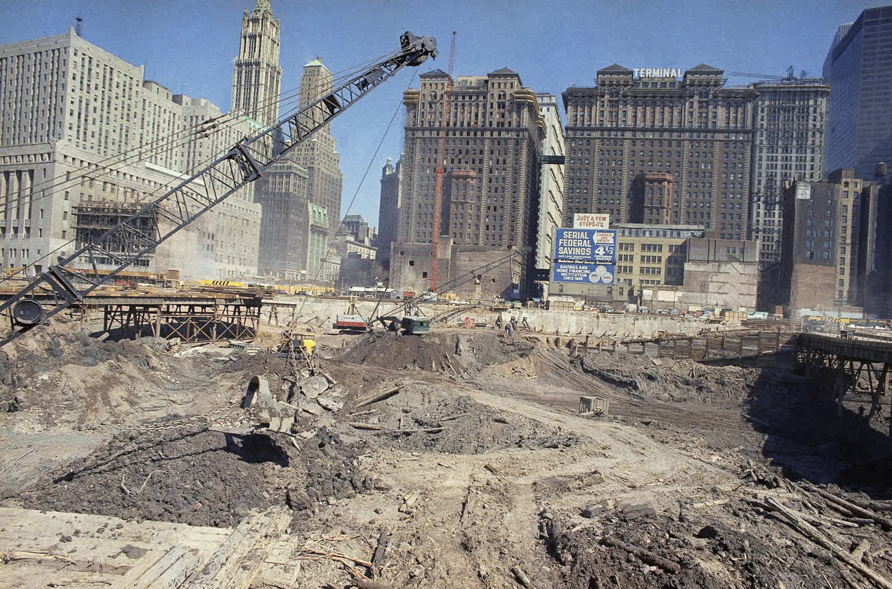 The excavated World Trade Center construction site in 1968, with a crane and Lower Manhattan's older skyline behind