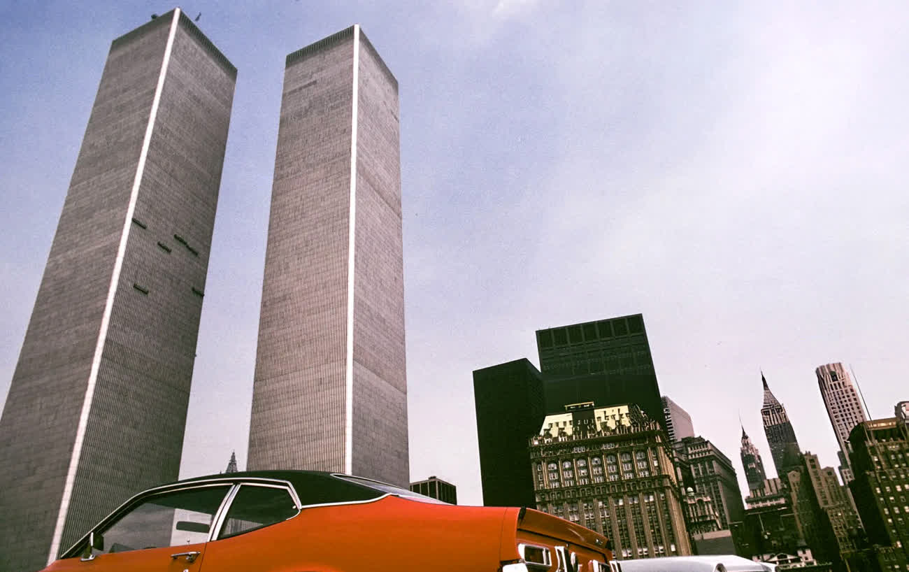 The completed Twin Towers of the World Trade Center in 1974, with a 1970s car parked in the foreground